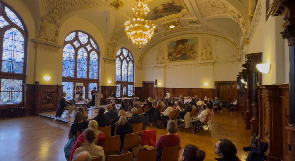 Menschen verfolgen eine Debatte in einem großen Saal